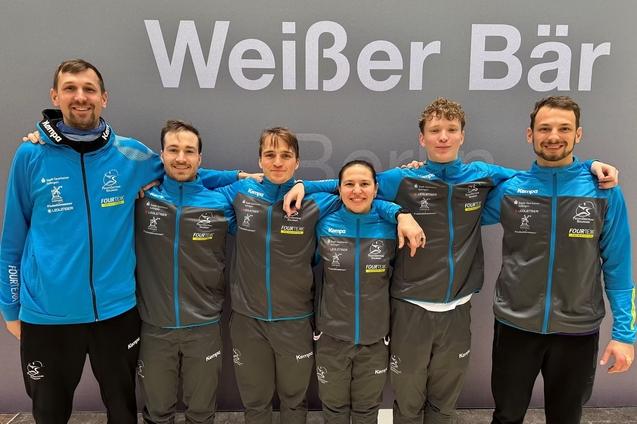 Sechs Personen in Sportbekleidung posieren l&auml;chelnd vor einem Hintergrund mit dem Schriftzug &bdquo;Wei&szlig;er B&auml;r&ldquo;.